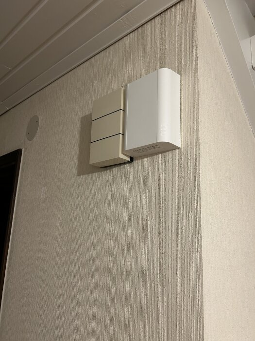 Väggmonterad Ring-dosa och Aqara G4 ringklocka installerade inomhus i ett hem med ljusa väggar och takpanelen ovan.