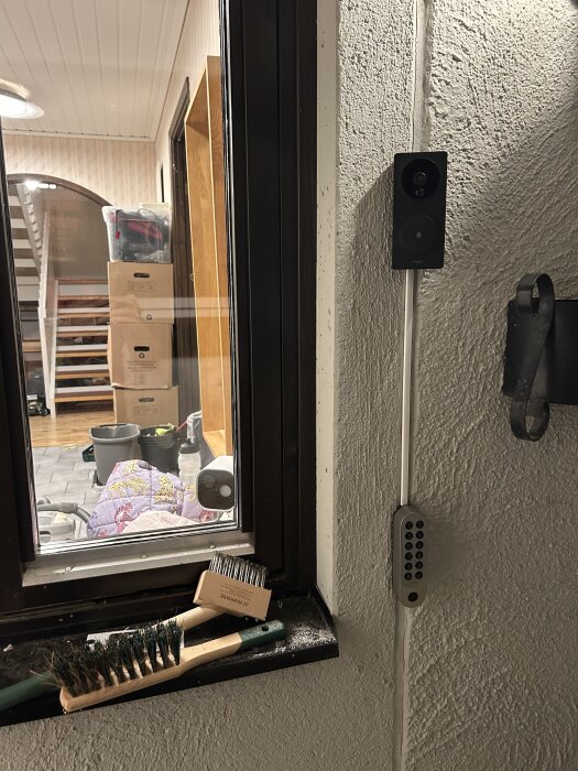 Videodörrklocka Aqara G4 installerad på vägg utomhus bredvid ett fönster, med kablar och en knappsats monterad under.