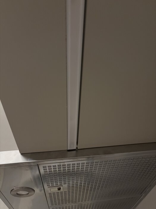 Glipa mellan täckskiva och kökslampa i Ikeakök, ojämn nivå på skarv och fnasiga sågkanter.