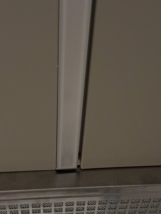 Glipa mellan Ikeaköks täckskiva och vägg, med lampa.  Ojämn nivå och fnasigt utfört arbete syns i bild.