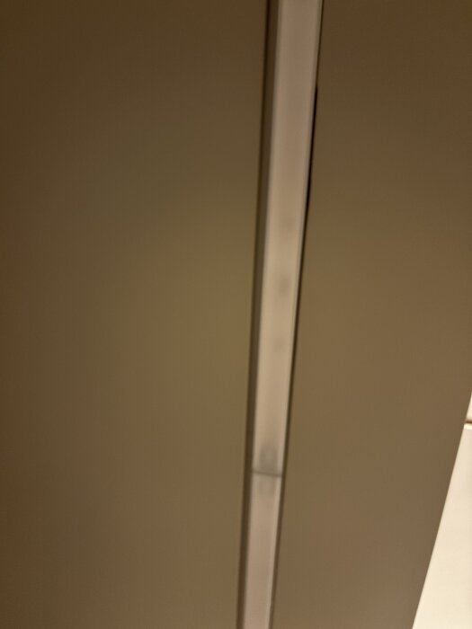 Glipa mellan täckskiva och lampa i ett Ikeakök, där installationen upplevs som slarvig med ojämna snitt och nivåskillnader.