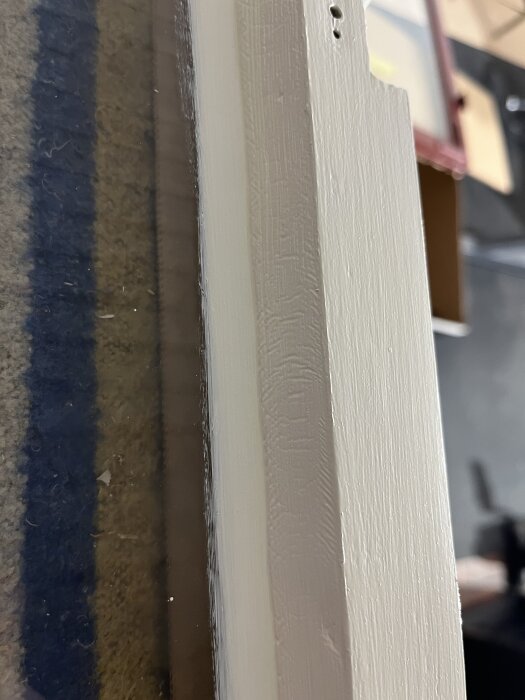 Skrynkligt kitt på innerbåge av fönster.