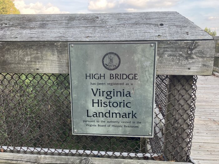 Skylt vid träbro med text som anger att High Bridge är ett historiskt landmärke i Virginia, enligt Virginia Board of Historic Resources.