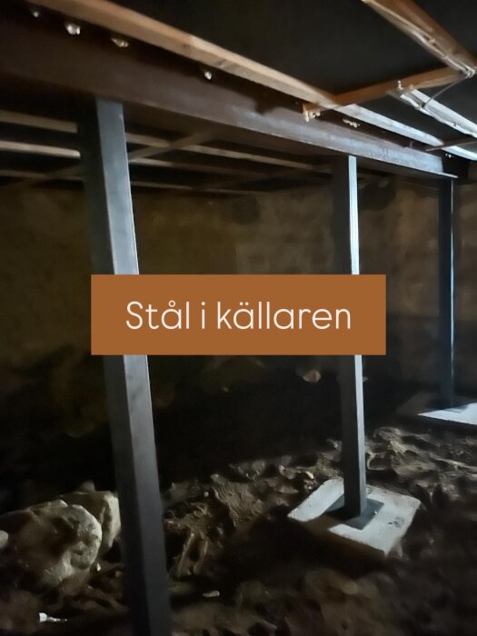 Stålstolpar i en källare, installerade som stöttor för bjälklaget, med fokus på robust konstruktion och gott om utrymme för jordvärmepanna.