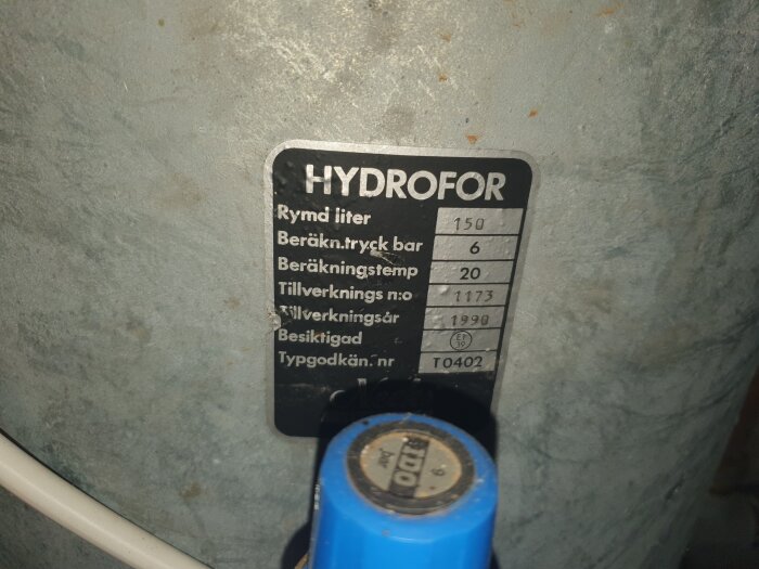 Etikett på en hydrofor 150 liter visar specifikationer: beräkningstryck 6 bar, tillverkningsår 1990.