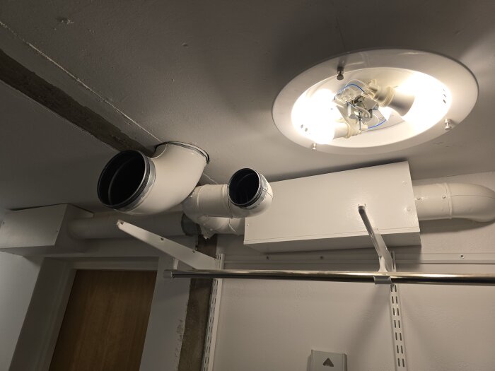 Ventilationsrör och belysning i taket på en byggarbetsplats. Röret förbereds för borttagning för att ge plats åt en ny vägg.
