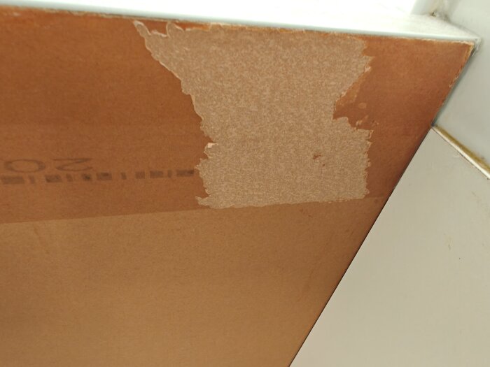 Bänkskiva med delvis borttagen skyddsplast, frilägger det yttersta lagret av materialet.