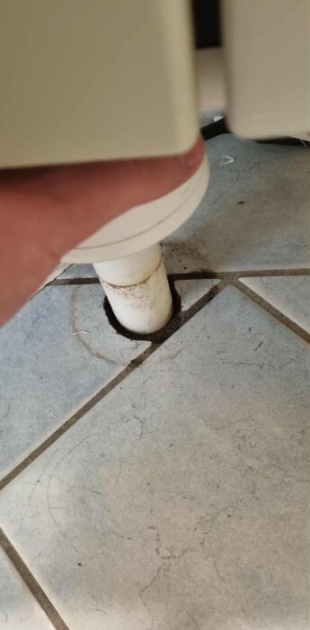 Rör som går genom kaklat golv med mellanrum runt, visar problem i våtrum.