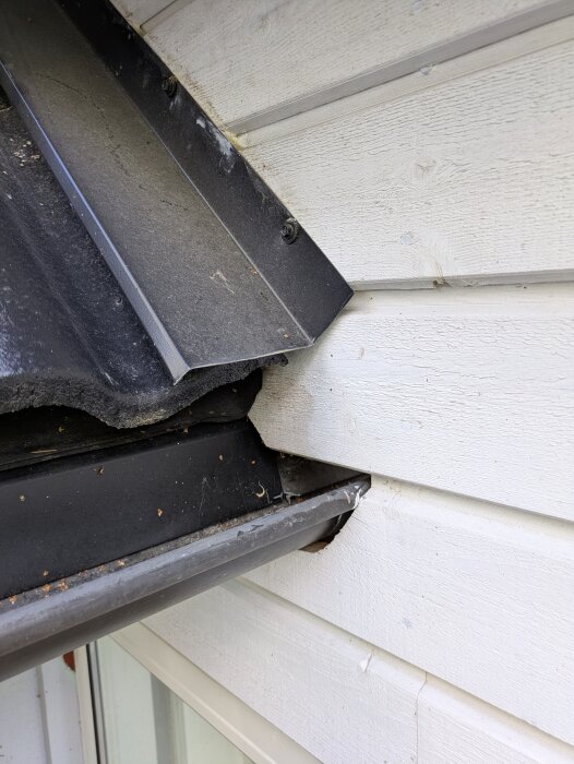 Hängränna fastmonterad vid husvägg med plåt och reglar, inglasat uterum under, diskuteras för avlägsnande eller förslutning för att undvika vattenläckage.