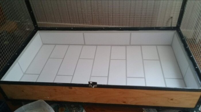 Voljär med kaklad botten gjord av vinkeljärn, plattjärn och putsnät, i ett byggprojekt för att skydda fåglar från att äta plastmatta.