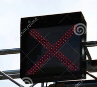 Vägmärkeskylt med ett rött kryss, indikerar stängd fil vid vägarbete.