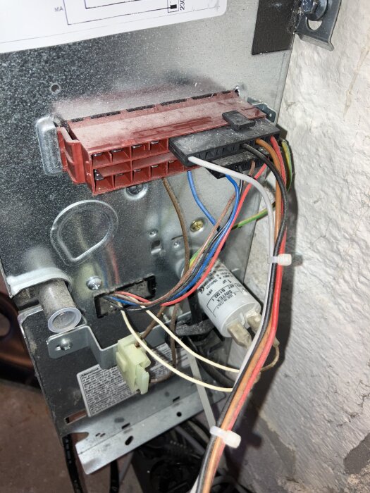 Elektriska trådar och kontakter inuti en fläkt, med färgade kablar anslutna till en kopplingsdosa, del av fläktfelsdiagnos.