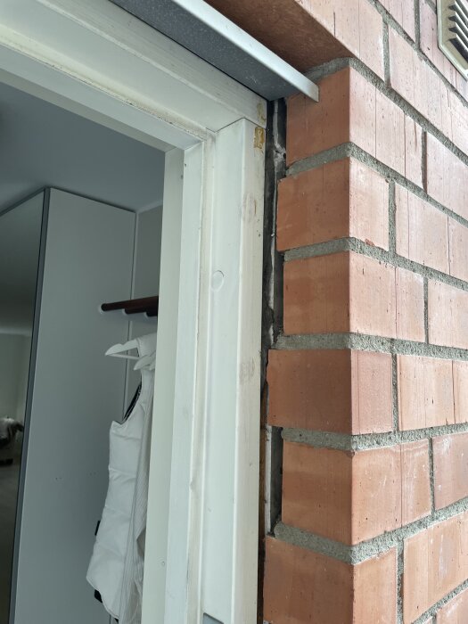 Glipa mellan tegelyttervägg och gips vid dörrkarm, visar behov av tätning; fråga gäller isolering eller fogskum för att åtgärda.