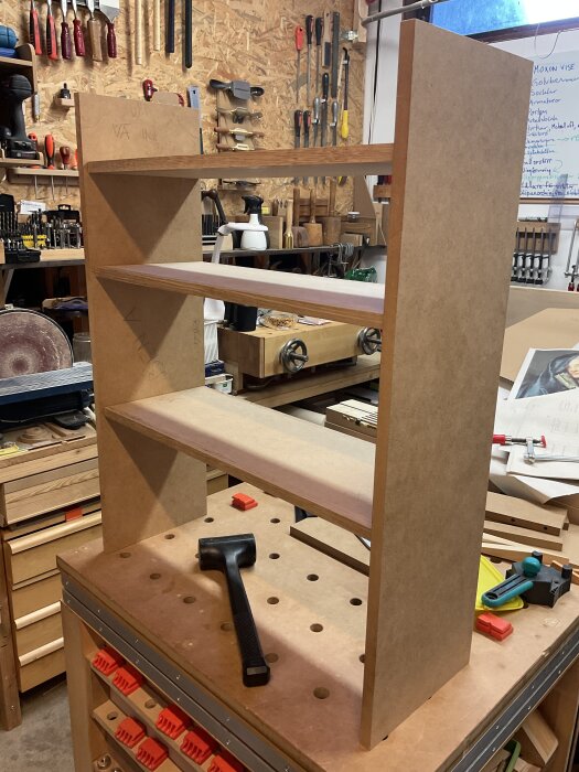 Halvfärdigt sideboard i MDF i verkstadsmiljö, verktyg runtomkring. Inga dörrar eller toppskiva ännu monterade.