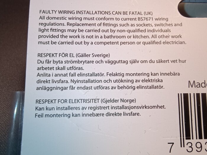 Text på förpackning till jordat skarvuttag med varningar för elarbeten i olika länder, inklusive specifika krav för Storbritannien, Sverige och Norge.