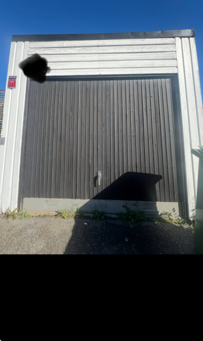 Garage med liggande vit panel och stående mörk panel.