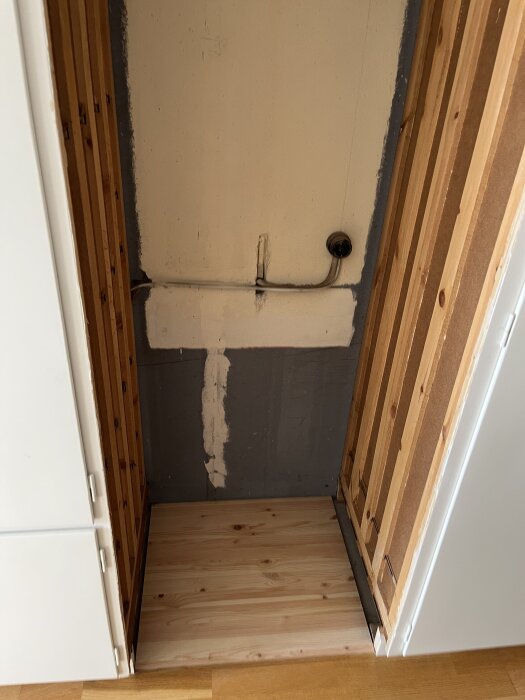 Utrymme för installation av kyl/frys med nytt trägolv och rödmålade reglar på sidorna, redo för en enhet 203 cm hög och 60 cm bred.