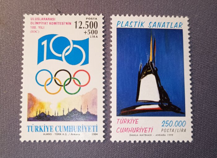 Två turkiska frimärken; ett med olympiska ringar och ett med konstmotiv, visar inflation med olika valörer, 12.500+500 lira och 250.000 lira.