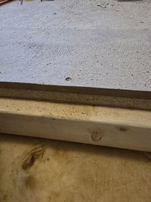 Bild av en golvbrunninstallation med en 22mm spånskiva ovanpå reglar och en 8mm MDF-skiva under.