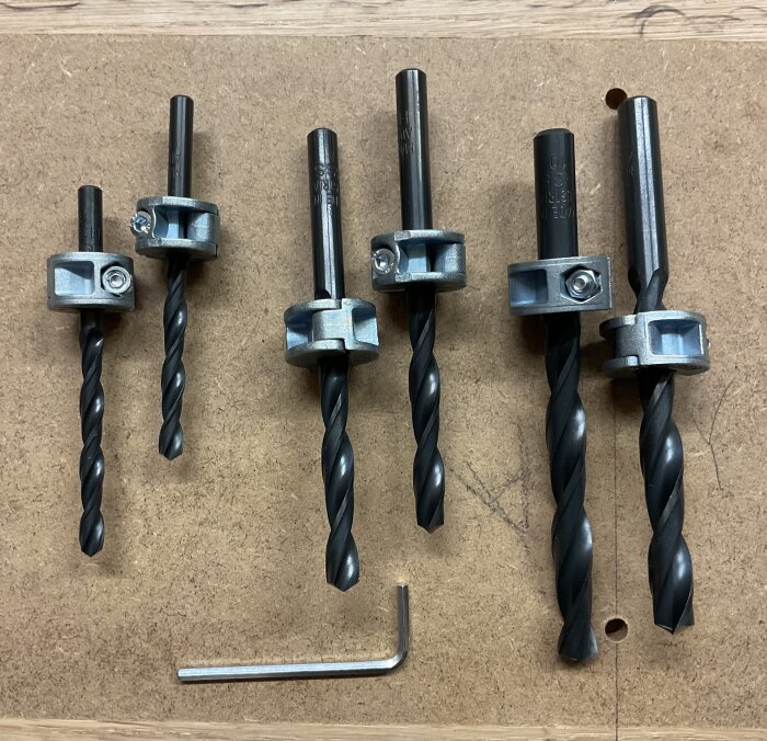 Borrar med djupstopp och insexnyckel på en arbetsyta, avsedda för användning med träpluggar i olika storlekar.