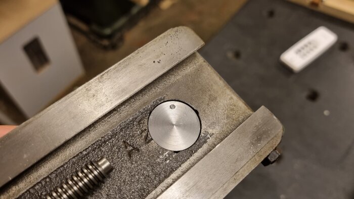 Närbild på en svarvad metalldel monterad med en skruv i en maskindel, eventuell verktygshållare med snabbfäste till en svarv.