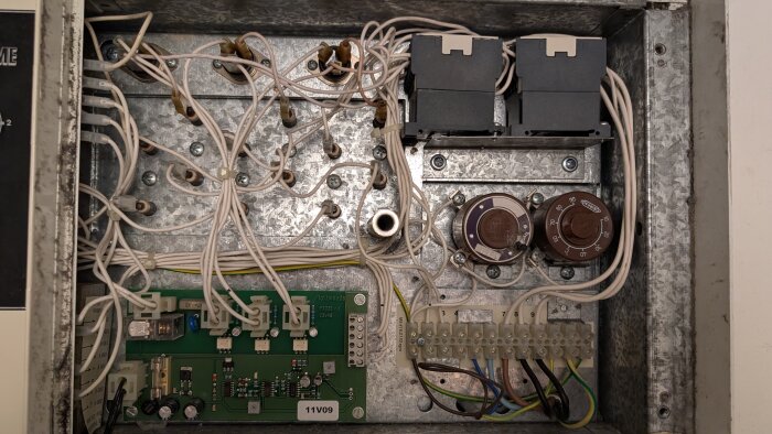 Kretskort och ledningar i en fläktkonfiguration, inklusive potentiometrar och anslutningar, med märkning "Fläktwoods" och kablar organiserade i en metalllåda.