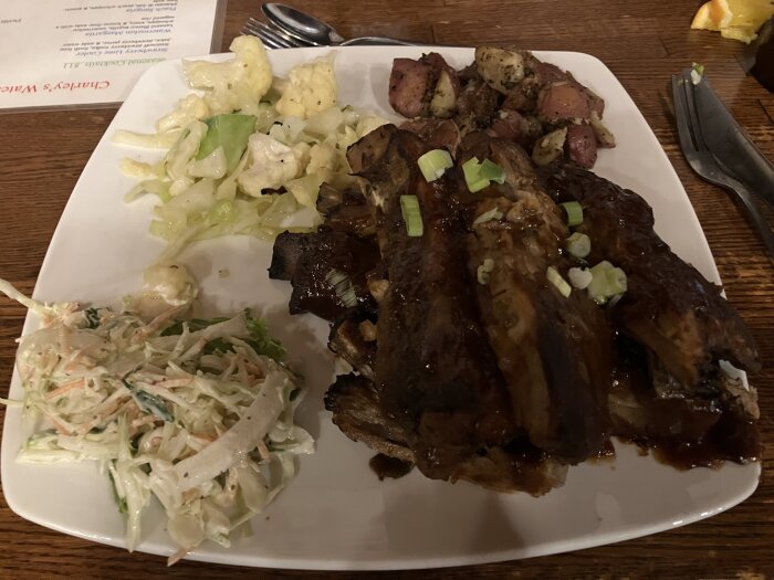 Tallrik med revbensspjäll, cesarsallad och coleslaw.
