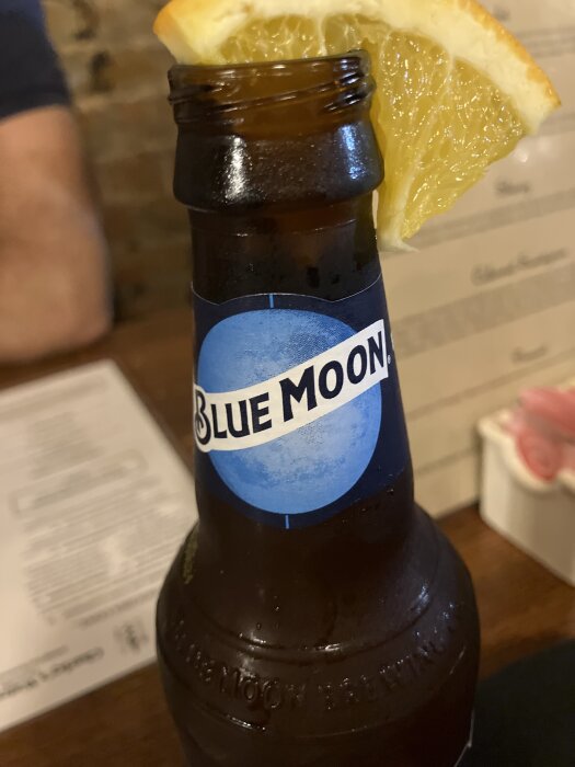 Flaska Blue Moon öl med en apelsinskiva på kanten.