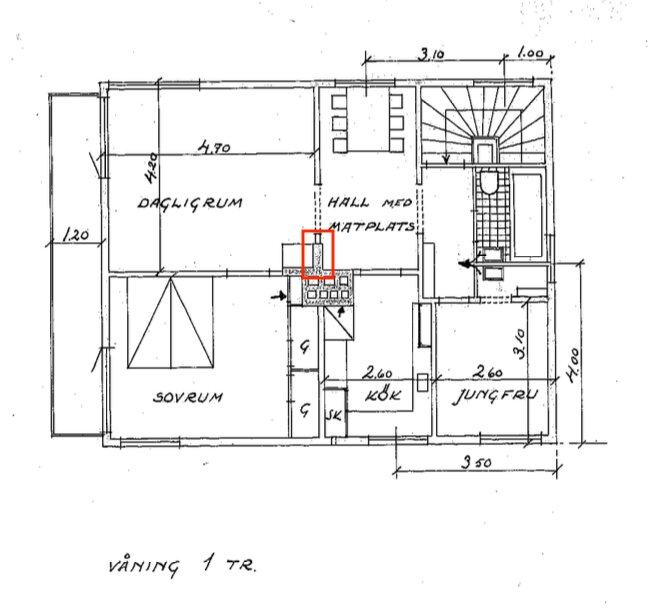 Planritning som visar en våning med sovrum, kök och hall. En röd markering visar en öppen spis mot en tjock vägg i vardagsrummet.