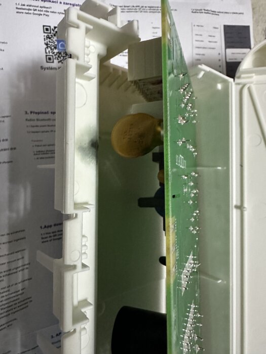 Kretskort från diskmaskin med bränd fläck nära gul komponent, potentiellt orsak till funktionsfel.