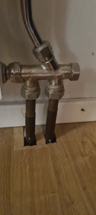 Radiatorkoppel med två anslutningar och rör som går genom golvet, avståndet är 35 mm från centrum till centrum.