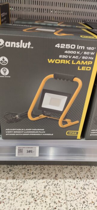 Förpackning av en LED-arbetslampa med 4250 lumen, 4000 K, och IP65-klassning, visas på en butikshylla.