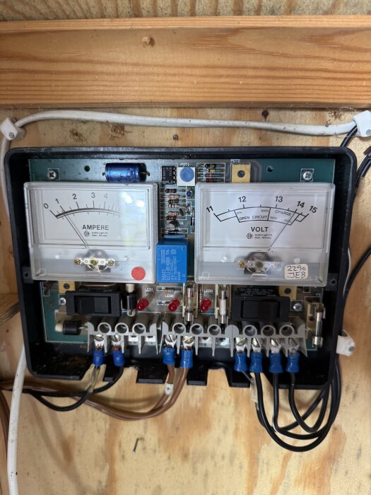 Analog solcellsanläggning KBS-3A med ampere- och voltmätare, kablar och säkringar monterad på trävägg, från Audio Light AS, Oslo.
