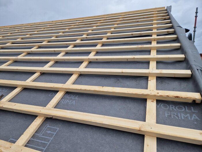 Tak under konstruktion med träreglar på diffusionsduk, 70-talsvilla, klart för plåtarbete.