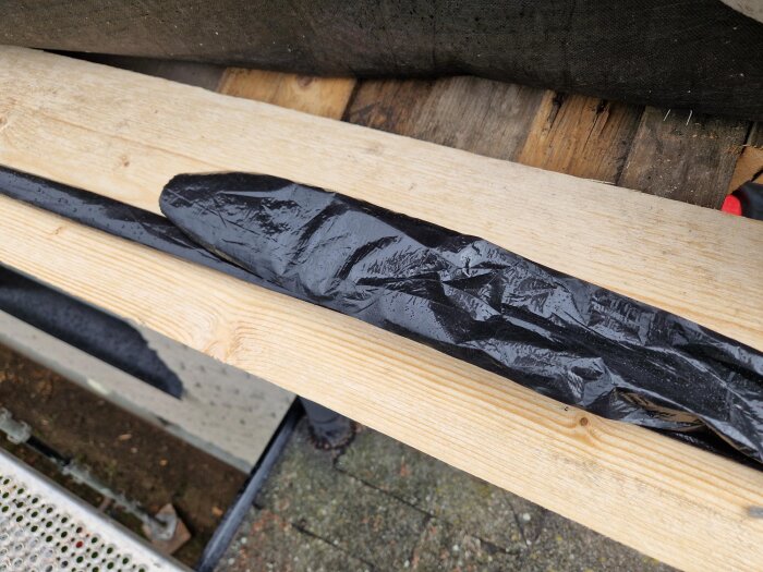 Plåtarbete och svart diffusionsduk på takfotsbräda på ett nyligen bytt tak. Regnvåta ytor syns på byggnadsstället.