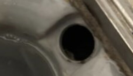 Gammal brunn med renshål utan propp, del av diskussion om luktproblem.