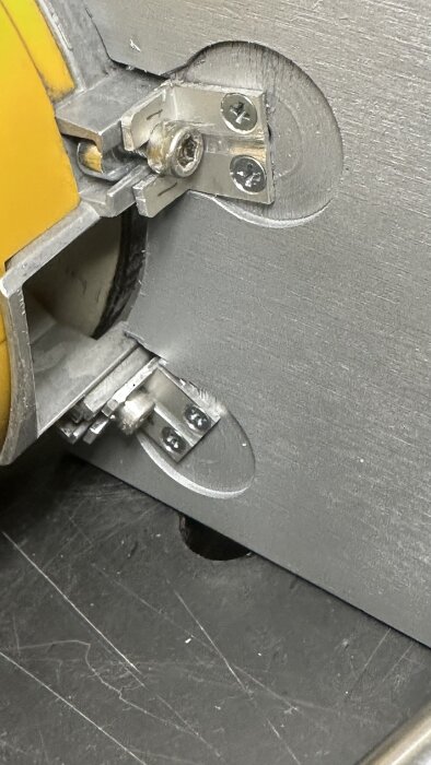 Närbild av en anpassad extrabordsanslutning i metall för slipmaskinen WS2000, med vinkelfästen och monterade skruvar.