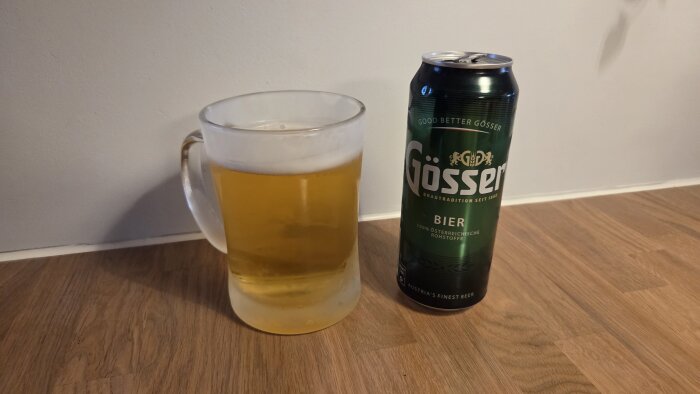 En glasstop med kall öl bredvid en burk öl från märket Gössner på ett träbord.