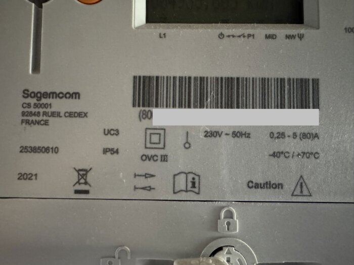 Etikett på baksidan av elektrisk spis, med information om modell, tillverkare, och elektriska specifikationer som 230V, 50Hz.