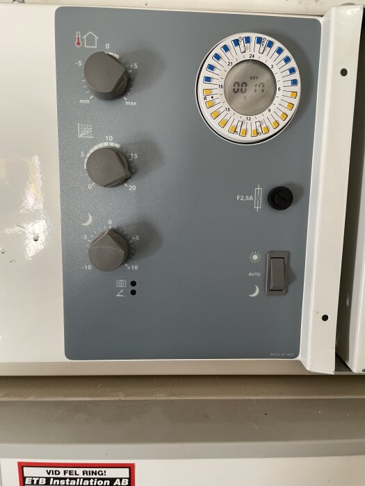 Kontrollpanel på elpanna Nibe EVC13 med tre vred, en timerklocka och en strömbrytare.