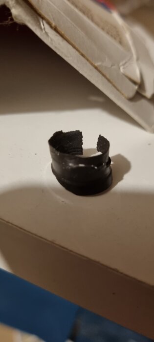 Trasig speedy sleeve i metall på ett bord, nämnd i byggforumdiskussion om fläktreparation.