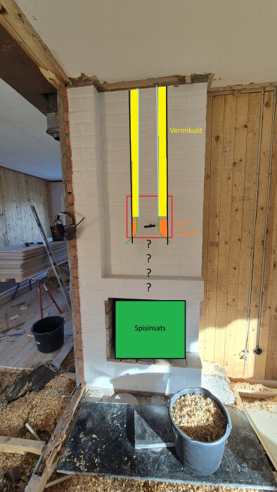 Spisinsatsinstallation med skisser av insatsrör och bottenkona i en gammal öppen spis, omgivande träpanel och verktyg på golvet.