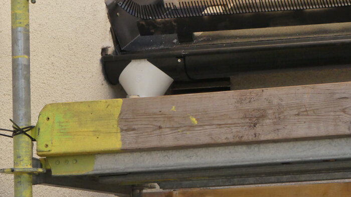 Omvikningskupa och vit stuprörsanslutning monterad på fasad, diskussion om färgbyte.