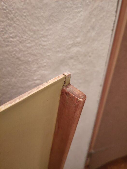 Närbild på kanten av en dörr med en list på ena sidan, sannolikt för att ge stadga, i ett renoveringsprojekt.