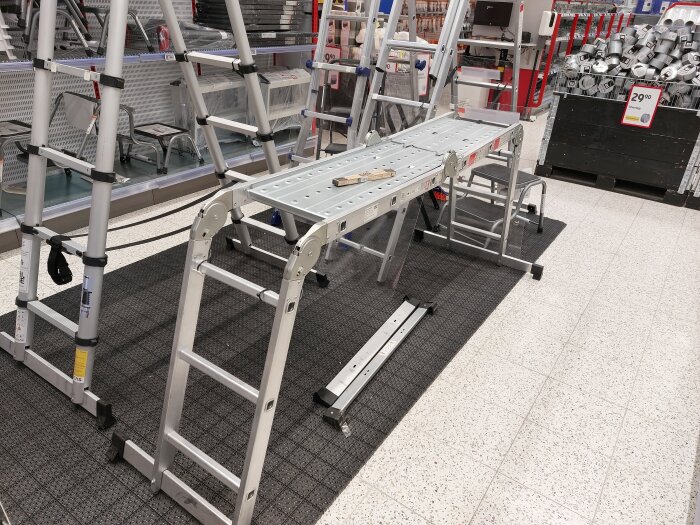 Aluminiumstegar och en multistege med plattform visas på en butiksyta.