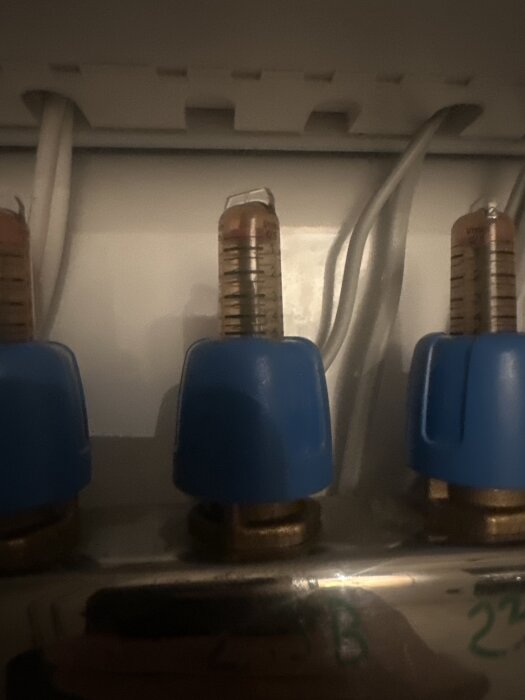 Rörsystem med flödesmätare och blå justeringsrattar, diskuteras i samband med golvvärmeprojekt och vattenflöde.