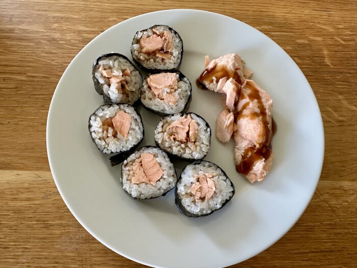 Sushirullar fylls med lax på vitt fat.