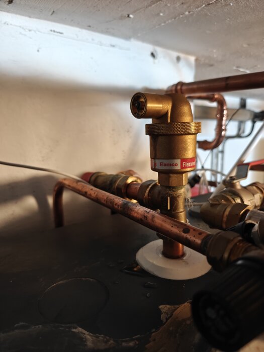 Ventil från Flamco Flexvent med kopparrör i ett rörsystem, lite vatten syns på ytan, potentiellt droppande område.