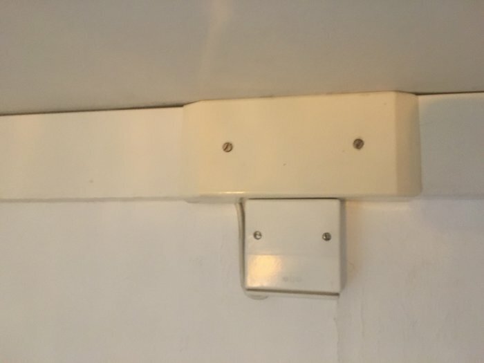 Väggmonterad elektrisk dosa med plastskydd, gammaldags stil.