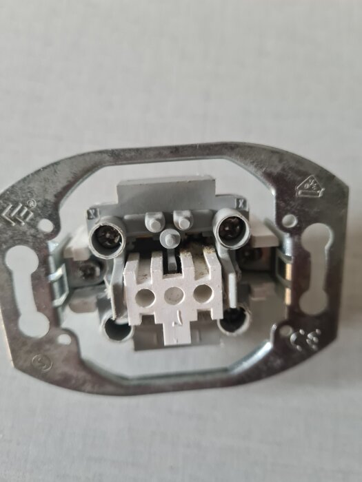 Strömbrytare med kopplingspunkter för sladdar, sett framifrån.